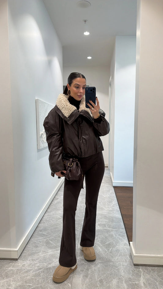 Coffee-colored leather jacket with fur collar and side pockets.